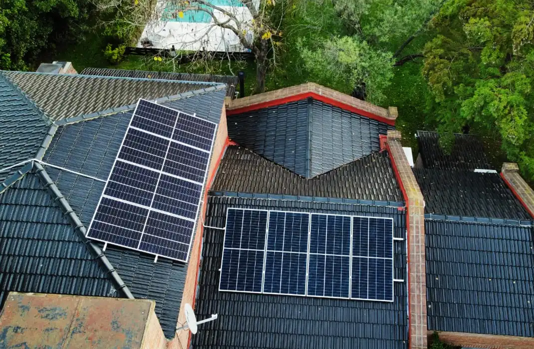 Casa con dos arreglos de paneles sobre tejas